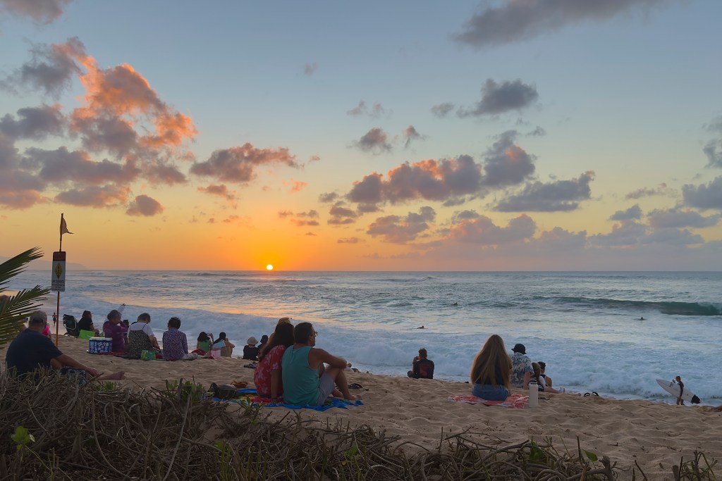 One of the premier North Shore Surfing locations shares the role of being one of Oahu's best beaches to watch a sunset. Tourists and locals alike gather October 15th to watch the Sun drift below the horizon. (David Croxford/Civil Beat/2024