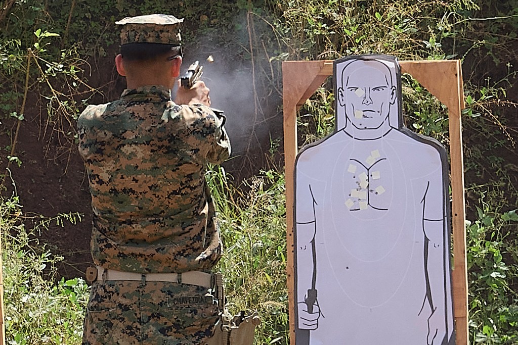 The shell casing of a 9mm handgun round is discharged to the right of the weapon as the Marine practices on the 9mm handgun 3 meter range at Marine Corps Base Hawaii Puuloa Training facility in Ewa Beach. (David Croxford/Civil Beat/2024)