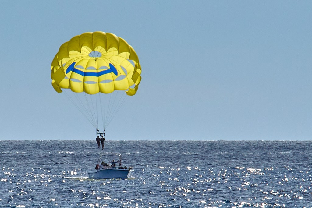 One of the signs that tourism is continuing to rebound after the Covid 19 ’slouch’ is the tourism-type activities that abound in places like Waikiki, Ala Moana Beach Park and Kewalos Basin harbor.  This Parasailing pair were observed returning to the boat after spending their time aloft in front of Ala Moana Beach Park during the afternoon, October 22, 2024. (David Croxford/Civil Beat/2024)