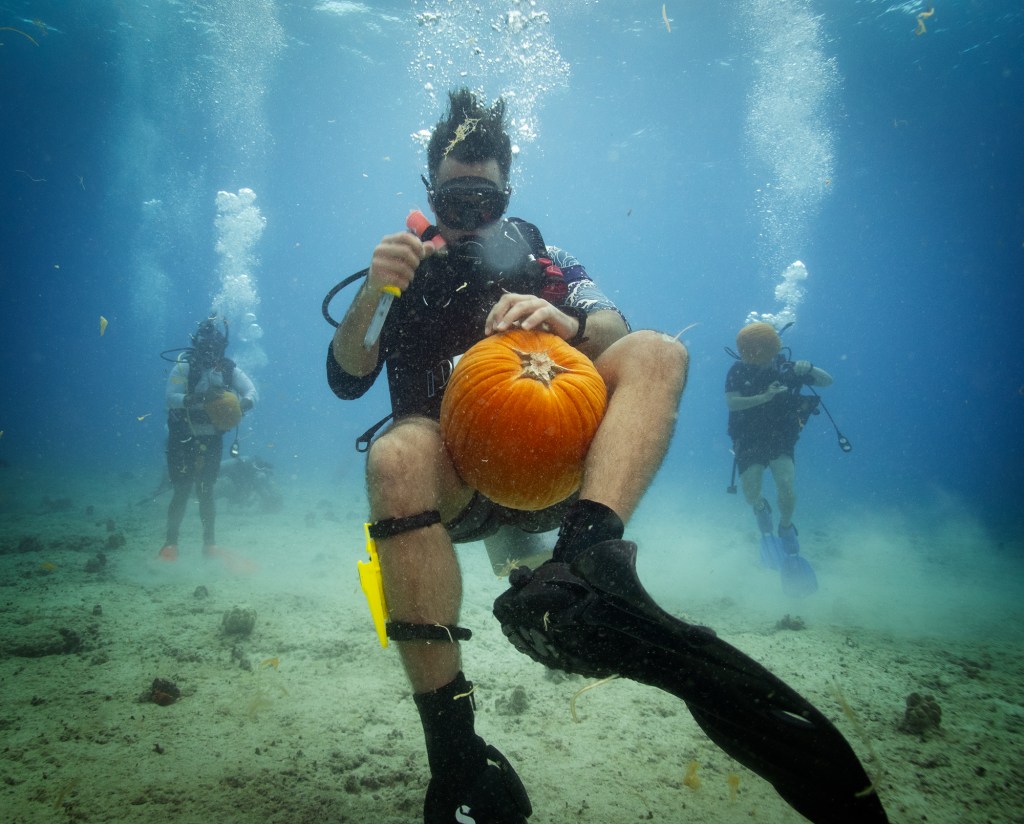 Clayton Bush carves his pumpkin during an Island Divers Hawaii underwater pumpkin carving contest Saturday, Oct. 26, 2024, in Honolulu. (Kevin Fujii/Civil Beat/2024)