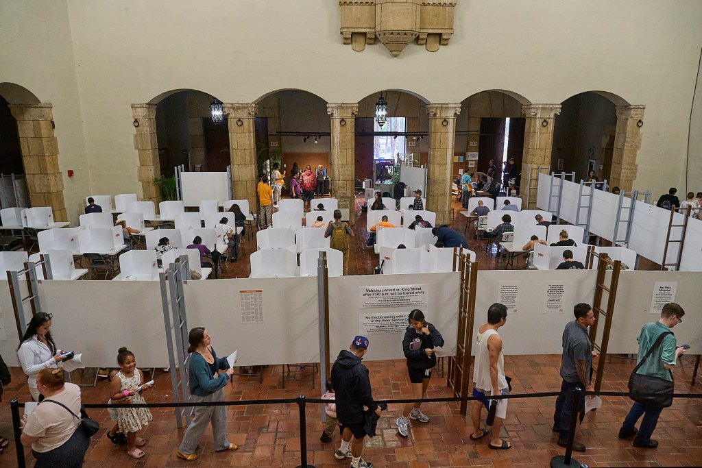 Voters in early voting at Honolulu Hale on King Street in Honolulu were met with torrential downpours as they drove through the election only lane that had been set aside and coned to allow drivers to either hand off their ballots to Poll workers or drop them into several Ballot boxes placed and manned along King Street. (David Croxford/Civil Beat/2024)