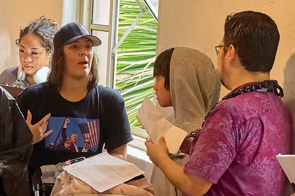 Potential Voter asked to remove her Trump Fist Pump shirt before voting..Voters in early voting at Honolulu Hale on King Street in Honolulu were met with torrential downpours as they drove through the election only lane that had been set aside and coned to allow drivers to either hand off their ballots to Poll workers or drop them into several Ballot boxes placed and manned along King Street. (David Croxford/Civil Beat/2024)
