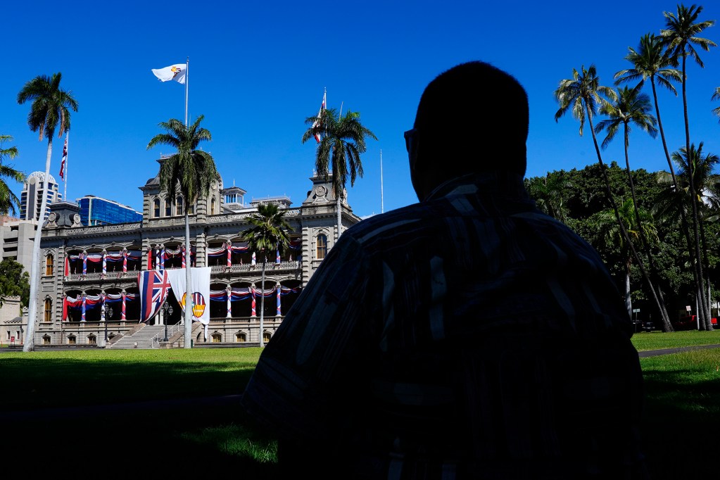 Ahukini Fuentes enjoys his lunch in the shade while enjoying the view of Iolani Palace dressed up to celebrate King David Kalakaua’s birthday Wednesday, Nov. 20, 2024, in Honolulu. King Kalakaua was born Nov. 16, 1836. He was the last king and monarch of the Kingdom of Hawaii from Feb. 12, 1874 until his death Jan. 20, 1891. (Kevin Fujii/Civil Beat/2024)