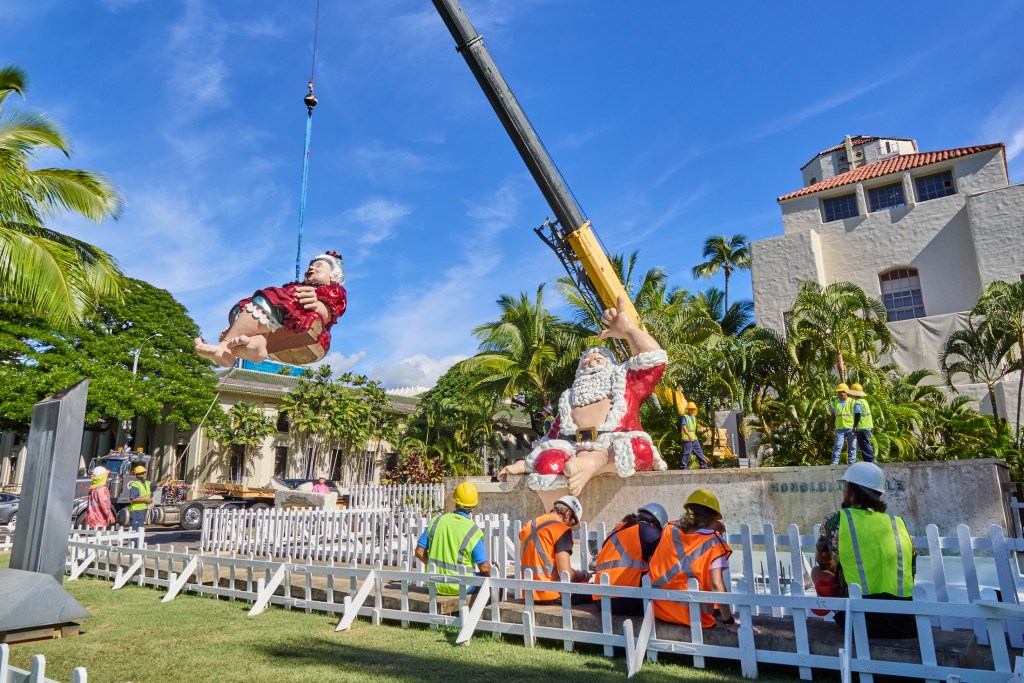 Honolulu’s Tutu Mele was lifted from the flatbed truck that had transported her from the storage facility to Honolulu Hale where she was placed alongside Shaka Santa to be one of the main display elements for the Honolulu City Lights Parade on December 7th (David Croxford/Civil Beat/2024)
