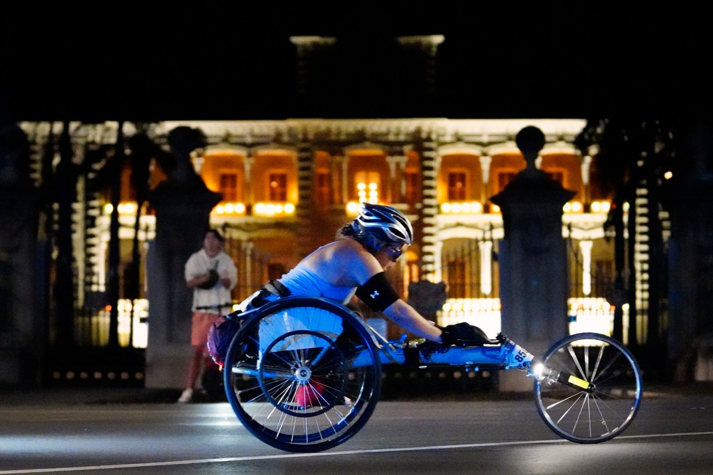 Dawna Zane passes Iolani Palace during the 52nd Honolulu Marathon Sunday, Dec. 8, 2024, in Honolulu. More than 35,000 registered to run, walk, roll 26.2 miles, Start to Park 10K or the Kalakaua Merrie Mile. (Kevin Fujii/Civil Beat/2024)