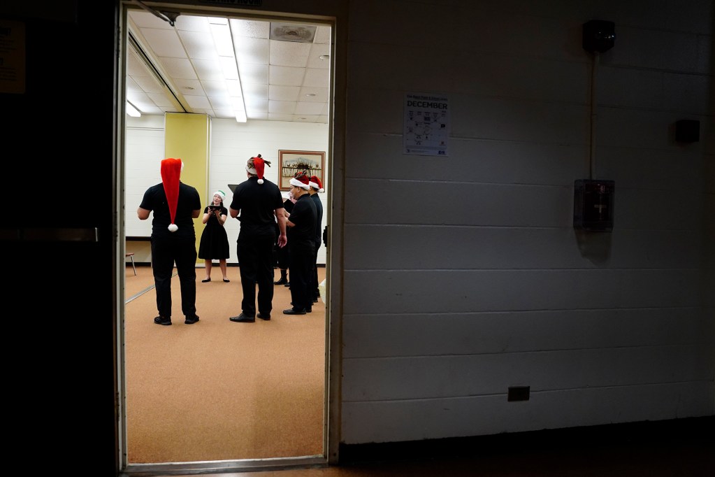 Karol’s Karolers are seen through a door as they perform Christmas carols at the Ewa Beach Public and School Library crowd Monday, Dec. 16, 2024, in Ewa Beach. (Kevin Fujii/Civil Beat/2024)