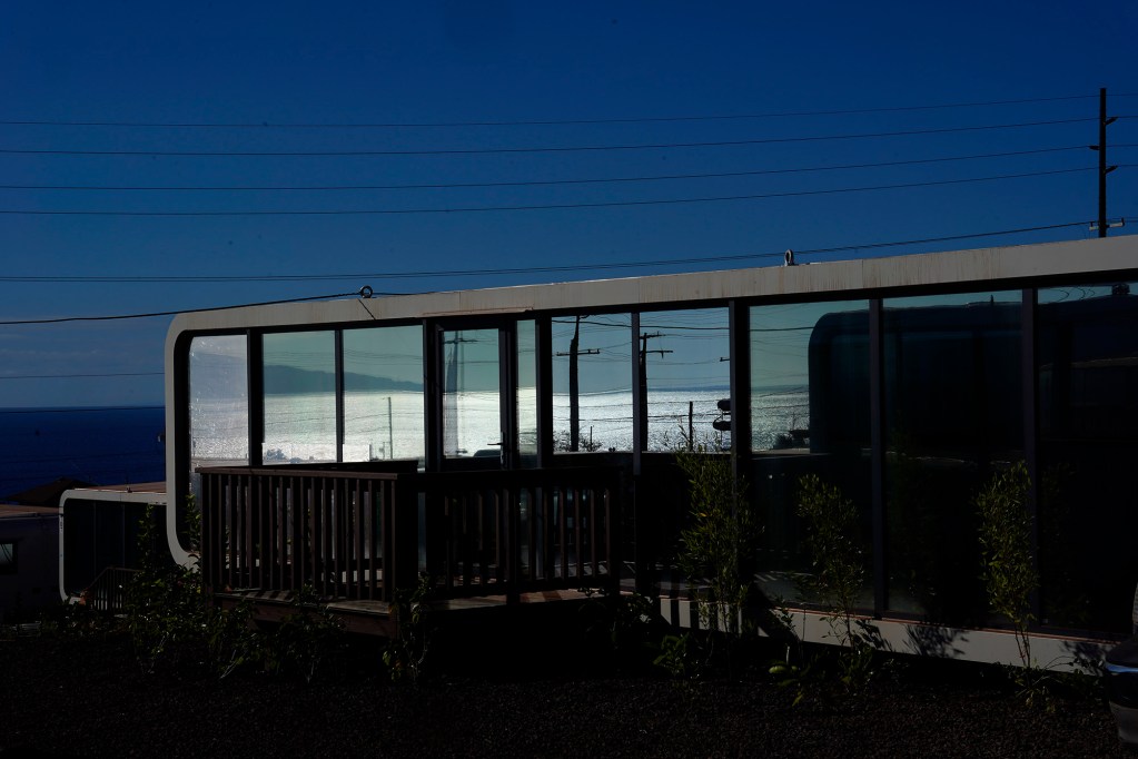 The Au’au Channel is reflected in a modern Ka La‘i Ola temporary home Thursday, Dec. 19, 2024, in Lahaina. Up to 1,500 fire survivors can live in these homes for up to five years. (Kevin Fujii/Civil Beat/2024)