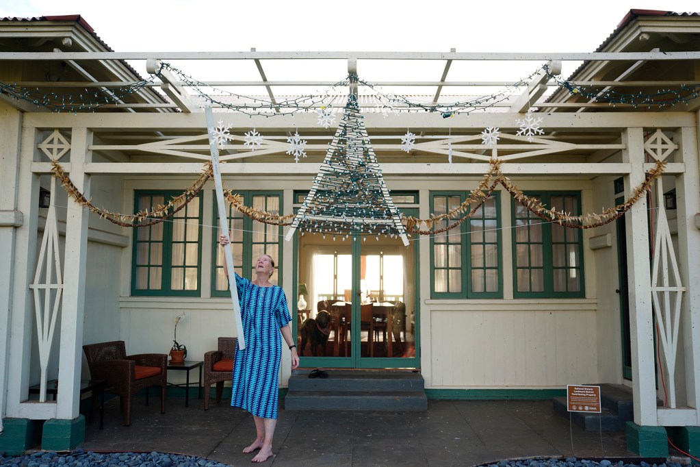 Dora Millikin untangles a Christmas decoration Thursday, Dec. 19, 2024, in Lahaina. The house made it through the Aug. 8, 2023, fire with very little damage. (Kevin Fujii/Civil Beat/2024)