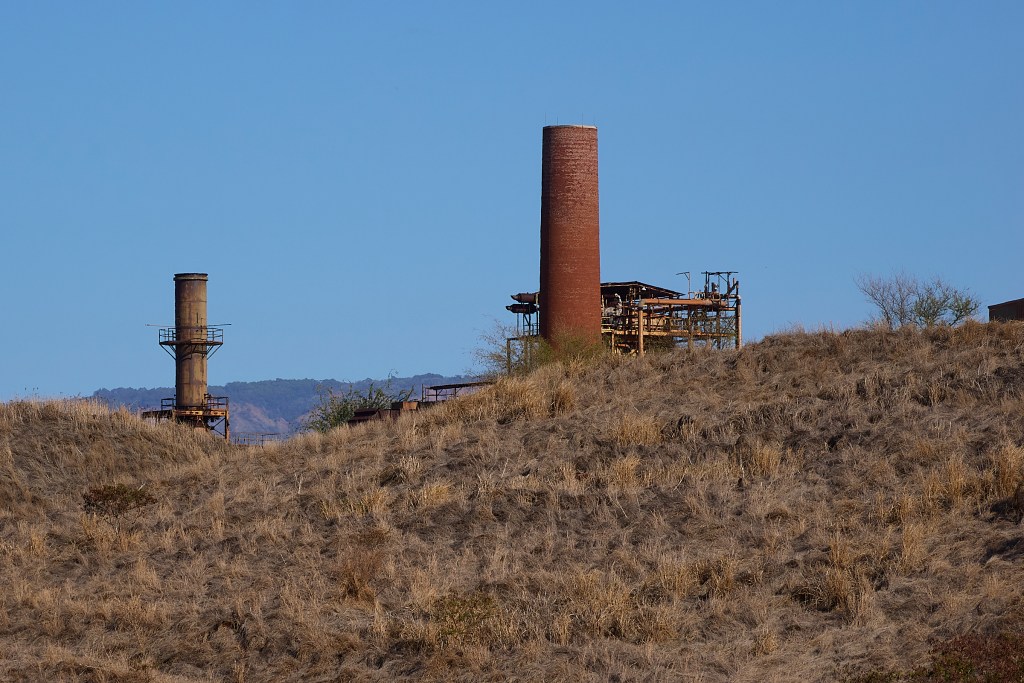 An alternate view of the Gay & Robinson Sugar Mill that was shuttered in 2010 after many decades of producing Sugar in the area. These hills in front of the smoke stacks are what remains of years of crushing the cane to extricate the sugar. (David Croxford/Civil Beat/2025)