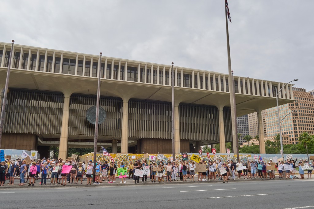 While most of Hawaii celebrated President’s Day 2025 spending time with their families, a vocally confrontational crowd crooned their opposition to President Trump’s attempts, with the help of Elon Musk, to follow through on President Obama’s Executive Order 13576 signed on June 13th 2011 whose thrust was to deliver an Efficient, Effective, and Accountable Government. (David Croxford/Civil Beat/2025)