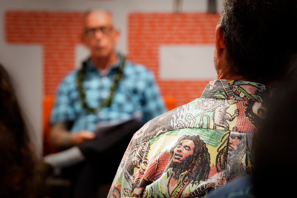 An attendee wears a Reyn Spooner Bob Marley aloha shirt during the Civil Cafe: Cannabis Policy in Hawaiʻi Friday, Feb. 21, 2025, in Honolulu. Panelists include Honolulu Prosecutor Steve Alm, John A. Burns School of Medicine Medical Expert on Drugs and Addiction Dr. Gerald Busch, Founder of Malie Cannabis Clinic Nurse Practitioner Me Fuimaona-Poe, Hawaiʻi State Representative House Judiciary & Hawaiian Affairs Committee Chair David Tarnas and Drug Policy Forum of Hawaiʻi’s Nikos Leverenz. (Kevin Fujii/Civil Beat/2025)