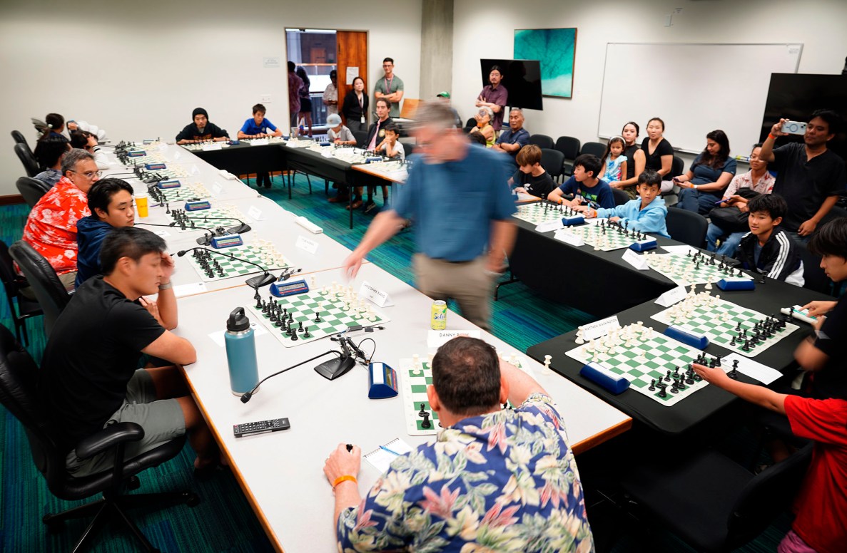 Thirteen-time State Champion National Master Cornelius Rubsamen is a blur of movement as he simultaneously plays 20 people during the Hawaiʻi Chess Federation’s installation at the Art at the Capitol Friday, April 11, 2025, in Honolulu. The theme for this year’s event is ‘Kālena, the Talent of Hawai‘i.’ (Kevin Fujii/Civil Beat/2025)