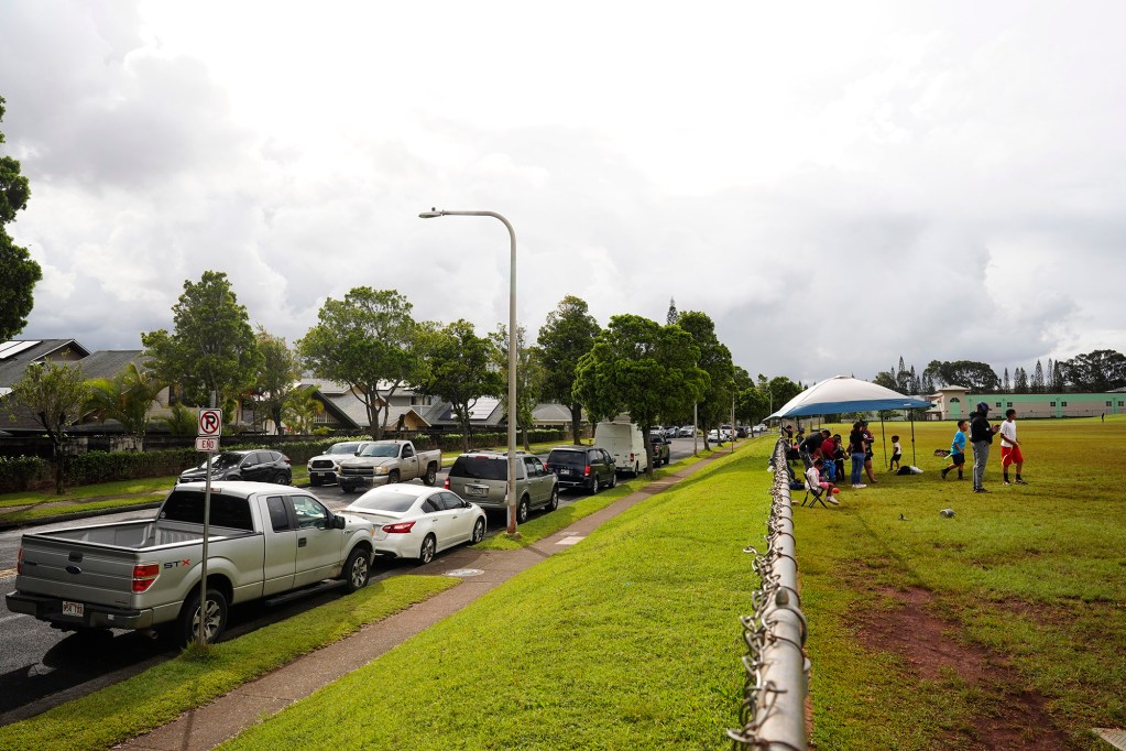Mililani Mauka Community Park users’ vehicles line Lehiwa Drive next to Mililani Middle School for Wednesday practice, April 16, 2025, in Mililani. On weekends, some parents arrive at 4:30 a.m. to get a parking space. A point of contention is the unused but locked Mililani Middle School parking lot on weekends. Parents say that it could alleviate parking problems. (Kevin Fujii/Civil Beat/2025)