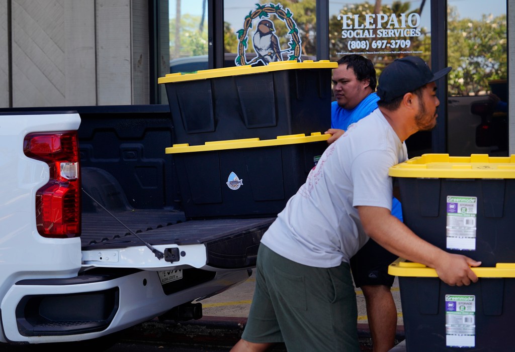 Waiʻanae High School graduates of the Marine Science Learning Center program Alex Totmon Rodriguez, left, and Tyson Arasato, deliver limu to ‘Elepaio Social Services Monday, April 21, 2025, in Waiʻanae. The program uses another name for their limu: ogo. Arasato, a 2007 graduate, now teaches the Career Technical Education (CTE) four levels of the program’s education sequence. Rodriguez, a 2018 graduate, is currently a KUPU intern with the program. ‘Elepaio is a part of the Waiʻanae Coast Comprehensive Health Center. They purchase limu from the Marine Science Learning Center and distribute the boxed limu to kūpuna free of charge. (Kevin Fujii/Civil Beat/2025)