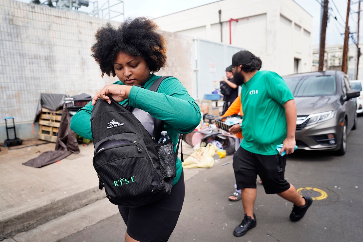 Kylé-Ann Bobo, an outreach case manager at Residential Youth Services and Empowerment, or RYSE, does outreach near Pūnawai Rest Stop on Kuwii Street Friday, April 25, 2025, in Honolulu. (Kevin Fujii/Civil Beat/2025)