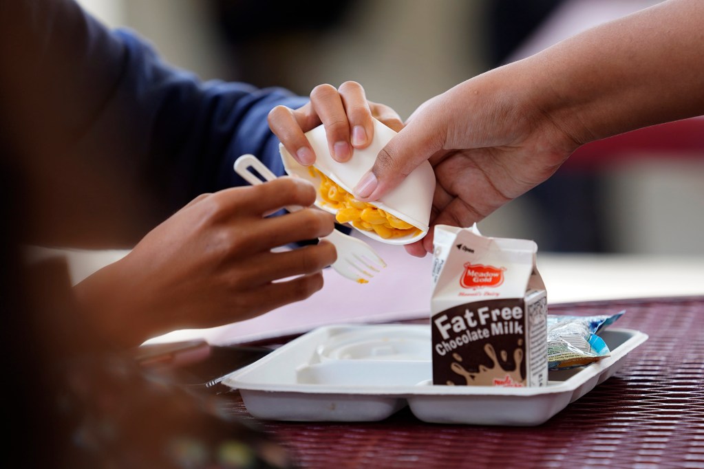 Castle High School students try to squeeze out the mac and cheese of a school lunch Monday, May 5, 2025, in Kāneʻohe. Other options available for lunch on this day included carrots, broccoli, pineapple, juice slush and a dinner roll. (Kevin Fujii/Civil Beat/2025)