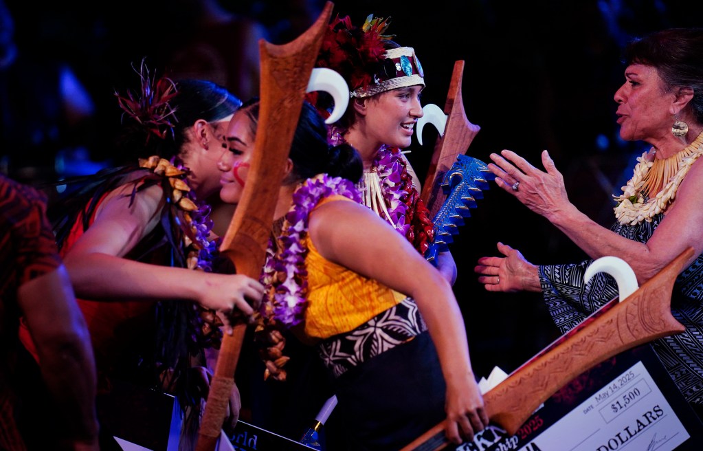 Judge Tanimalie Letuli, from right, congratulates the 2025 World Fireknife Championship winner Moeatalagi Schwenke, of Sydney, Australia, as second place Aaliya Ava, of Lā’ie, hugs third place Emillie Lovettm, of Aukland, New Zealand, after their championship round at the Polynesian Culture Center Wednesday, May 14, 2025, in Lā’e. (Kevin Fujii/Civil Beat/2025)