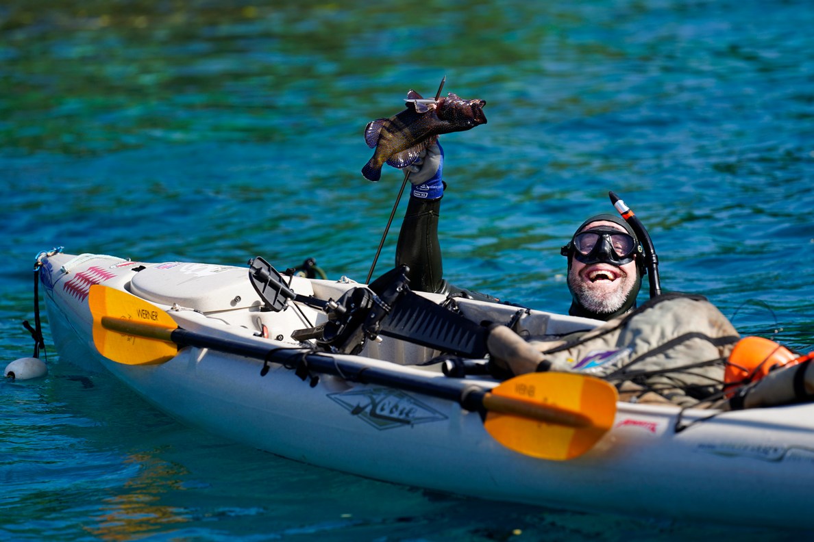Jeff Alberts proudly holds up a roi during the Kealakekua Bay Non-Native I‘a (fish) Removal Event Sunday, May 18, 2025, in Captain Cook. (Kevin Fujii/Civil Beat/2025)
