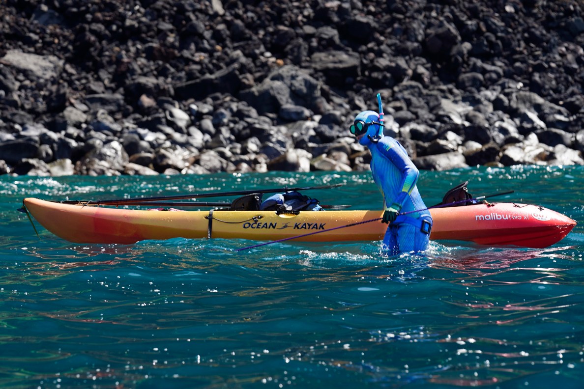 Brittany Brockway slips into the water for her turn to dive for the Kealakekua Bay Non-Native I‘a (fish) Removal Event Sunday, May 18, 2025, in Captain Cook. Those hui included: ‘Ike Lawai‘a, Kapukapu ‘ohana, Hawaiʻi Cooperative Fishery Research Unit, Healy Foundation, Alex & Duke DeRego Foundation, The Nature Conservancy, Department of Land and Natural Resources’ Division of Aquatic Resources. (Kevin Fujii/Civil Beat/2025)
