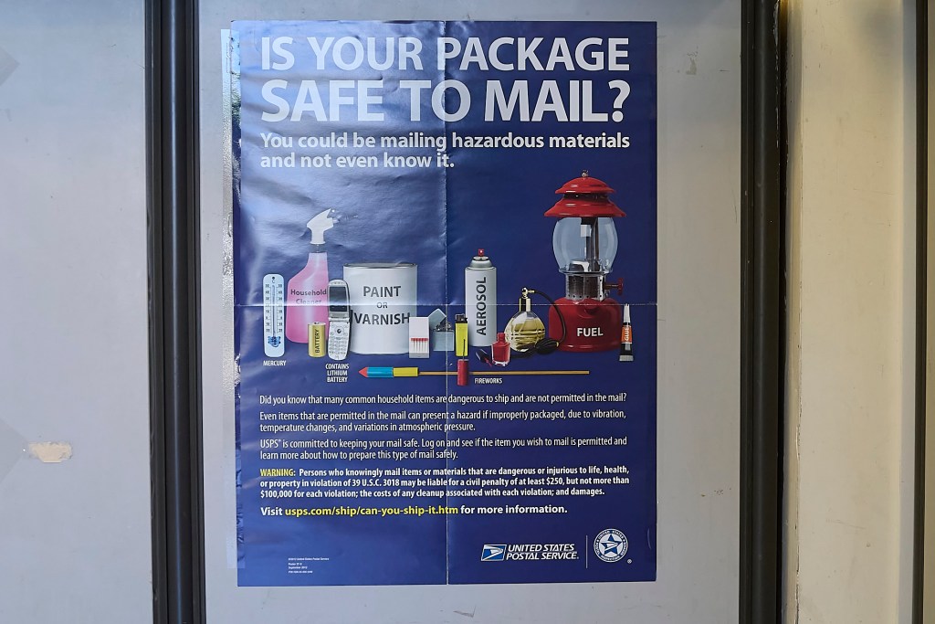 Faye Ono runs the Kaimuki Post Office and showed the questions that are displayed on the customer facing retail unit when packages are brought to the post office to be serviced and delivered.(David Croxford/Civil Beat/2025)