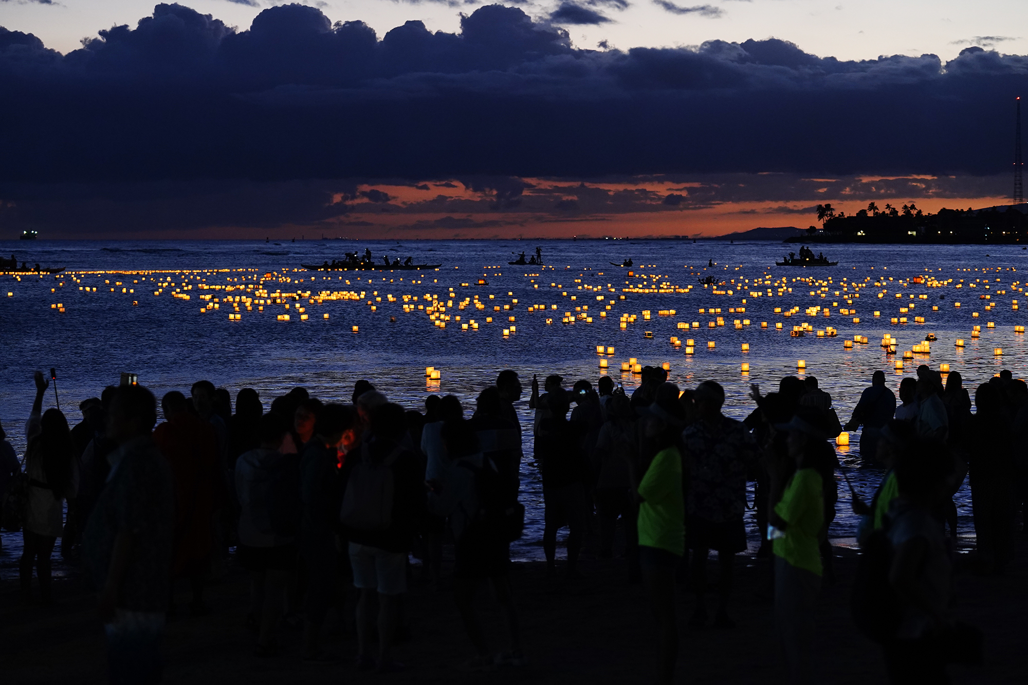 A portion of the estimated 40,000 people attending the 27th Annual Shinnyo Lantern Floating Hawaiʻi watch lanterns float away from Ala Moana Regional Park Monday, May 26, 2025, in Honolulu. 6,000 lanterns with messages to lost loved ones are launched by family members. (Kevin Fujii/Civil Beat/2025)