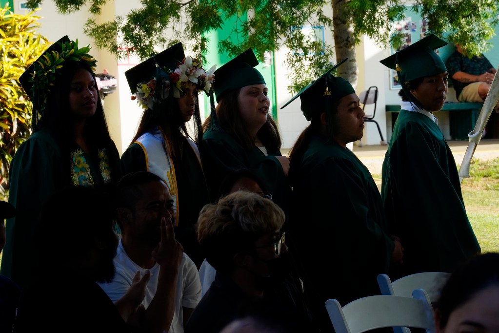 Five of seven Hawaiʻi School for the Deaf and Blind seniors line up as the graduating class of 2025Wednesday, May 28, 2025, in Honolulu. Thanicia Gideon, from left, Odreigh Maskell, Tessie Radle, Zion Sale and Mikaiah Ventura wait to be announced. (Kevin Fujii/Civil Beat/2025)