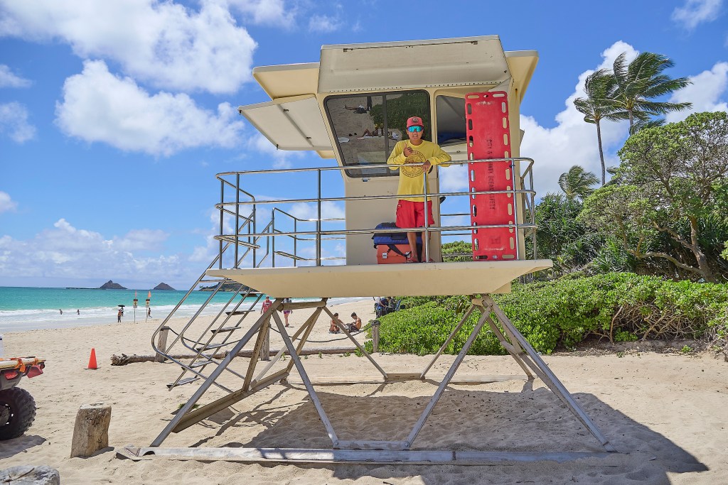 Kurt Lager, Honolulu City and County Ocean Safety Director is photographed at Kalama Beach Park in Kailua where typical safety signs warned of hazardous conditions that beach-goers seemed to ignore as they frolicked in the ocean.(David Croxford/Civil Beat/2025)