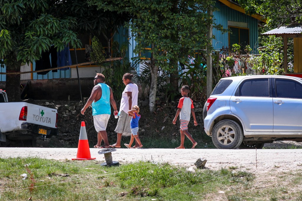 A family walks down a road in Honiara on Guadalcanal in the Solomon Islands. (Nathan Eagle/Civil Beat/2022)