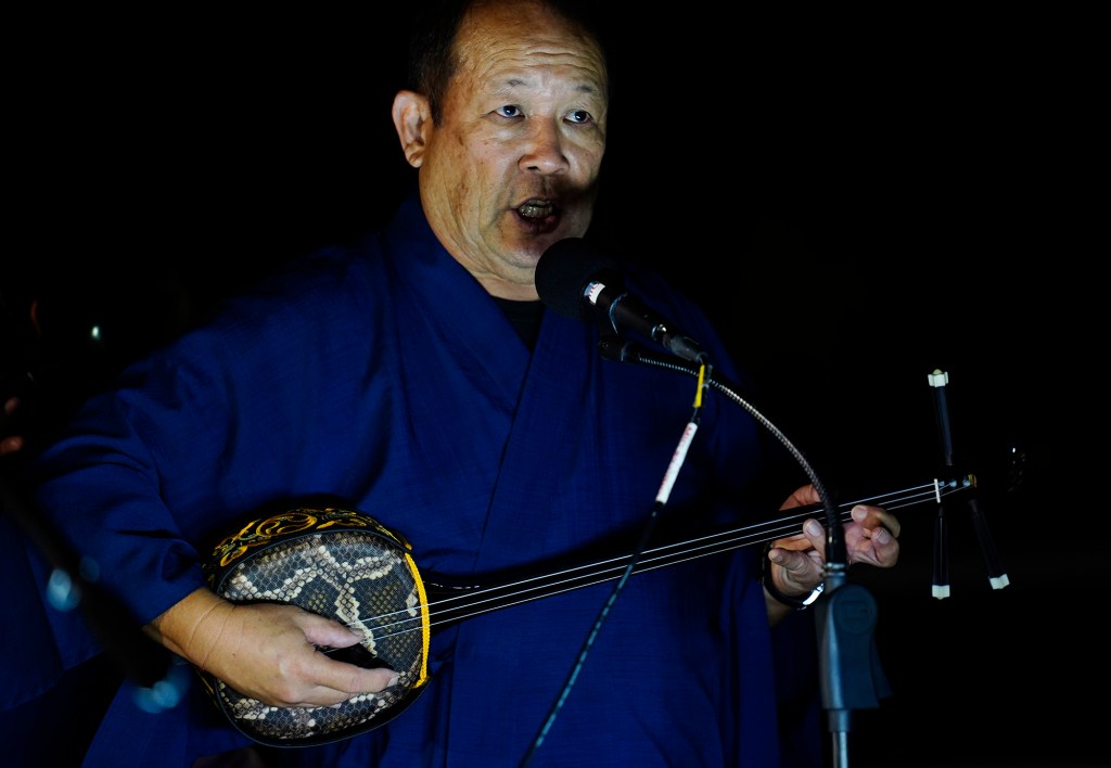 Hawaii Eisa Shinyuu Kai's Scot Izuka  plays the sanshin during the first Bon Dance of the season Saturday, June 7, 2025, at Hawaii’s Plantation Village in Waipahu. The summer Hawaii Eisa Shiny Kai performs Okinawa music. (Kevin Fujii/Civil Beat/2025)