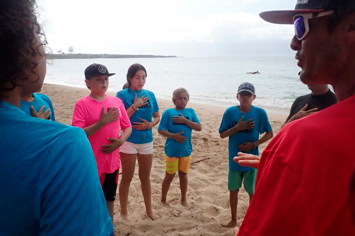 Maui Hero Project’s Joseph Anderson, DayJahiah Valdivia, Ocean Viera and Ivan Macias follow Kahākūahi Ocean Academy’s Zane Kekoa Schweitzer’s breathing exercise to re-center their selves after the beach physical training and lifeguard skills training Tuesday, June 10, 2025, in Lahaina. Anderson and Valdivia were affected by the Aug. 8, 2023, fires on Maui. (Kevin Fujii/Civil Beat/2025)