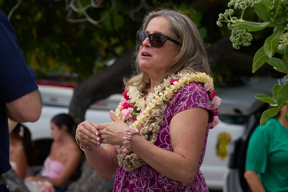 Rachel Able whose daughter drowned at Pine Trees Beach before the Lifeguard  Tower was installed is joined by members of the council and representatives from the mayors office as the tower is blessed on Friday June 13th.(David Croxford/Civil Beat/2025)