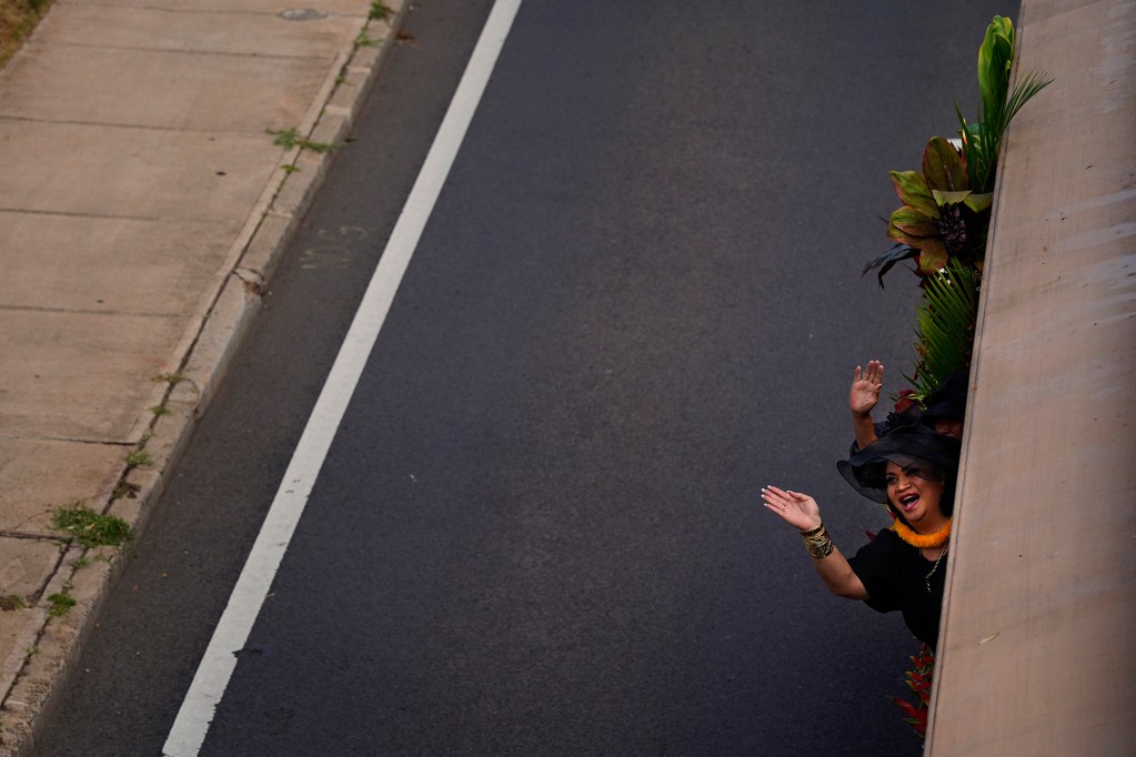 A member of the ‘Ahahui Ka‘ahumanu Society, Chapter I, Honolulu waves from their trolley in the 108th King Kamehameha Celebration Floral Parade Saturday, June 14, 2025, in Honolulu. In its 153 year, the King Kamehameha Day Celebrations honor Kamehameha I, the “Father of the Hawaiian Kingdom,” who united the Hawaiian Islands under one rule. His great-grandson King Kamehameha V established King Kamehameha Day in 1971. It was first observed on June 11, 1872. (Kevin Fujii/Civil Beat/2025)