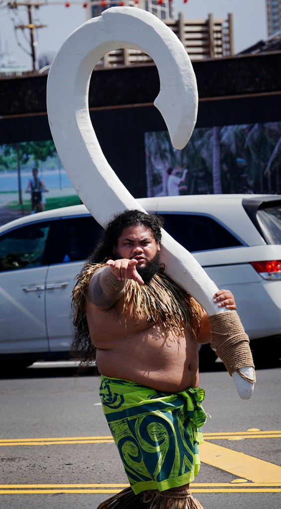 Māui, the Polynesian demigod made popular in the 2016 Disney film Moana, walks the Earth with his giant fish hook in the 108th King Kamehameha Celebration Floral Parade Saturday, June 14, 2025, in Honolulu. In its 153 year, the King Kamehameha Day Celebrations honor Kamehameha I, the “Father of the Hawaiian Kingdom,” who united the Hawaiian Islands under one rule. His great-grandson King Kamehameha V established King Kamehameha Day in 1971. It was first observed on June 11, 1872. (Kevin Fujii/Civil Beat/2025)