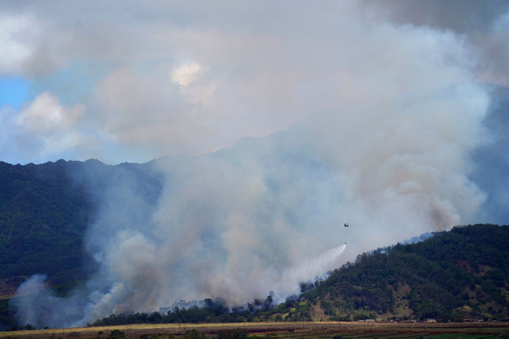 A chinook helicopter drops water on a vegetation fire on U.S. Army’s Schofield Barracks Monday, June 16, 2025, near Wahiawā. According to Hawaii News Now's website: the brush fire was 50% contained as of 7:00 a.m. Monday. It was first reported Sunday at 6:00 p.m. (Kevin Fujii/Civil Beat/2025)