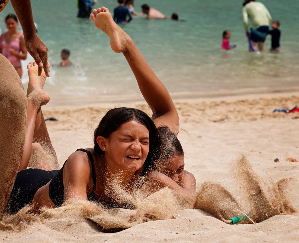 Sisters Gabby and Lanakila Patterson battle for a flag during Honolulu Ocean Safety Department’s Junior Lifeguard Program at Ko’olina Wednesday, June 25, 2025, in Kapolei. Their father is an Ocean Safety lieutenant. (Kevin Fujii/Civil Beat/2025)
