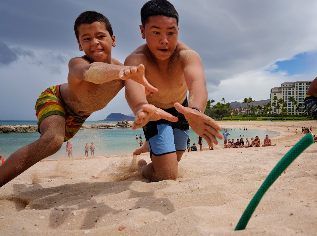 Elijah Mero, 12, left, and Raider Lee, 12, dive for a flag during the Honolulu Ocean Safety Department’s Junior Lifeguard Program at Ko’olina Wednesday, June 25, 2025, in Kapolei. (Kevin Fujii/Civil Beat/2025)