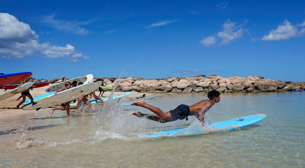 Honolulu Ocean Safety Department’s Junior Lifeguard Program participants Isaiah Smith, 16, flies into action to practice a surfboard rescue program at Ko’olina Thursday, June 26, 2025, in Kapolei. (Kevin Fujii/Civil Beat/2025)