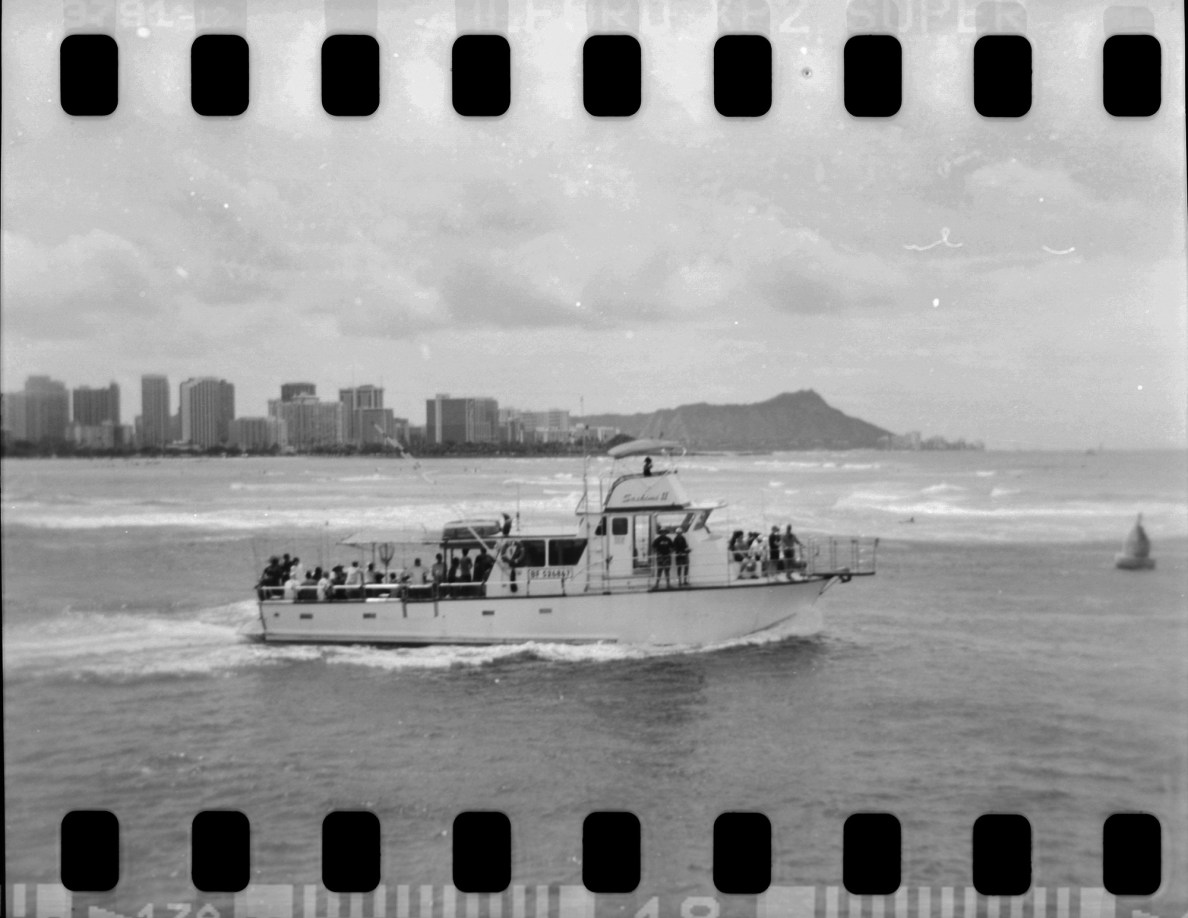 A tourist boat leaves Kewalo Basin during a 35mm film in a Holga for a test shoot Friday, June 27, 2025, around Honolulu. (Kevin Fujii/Civil Beat/2025)