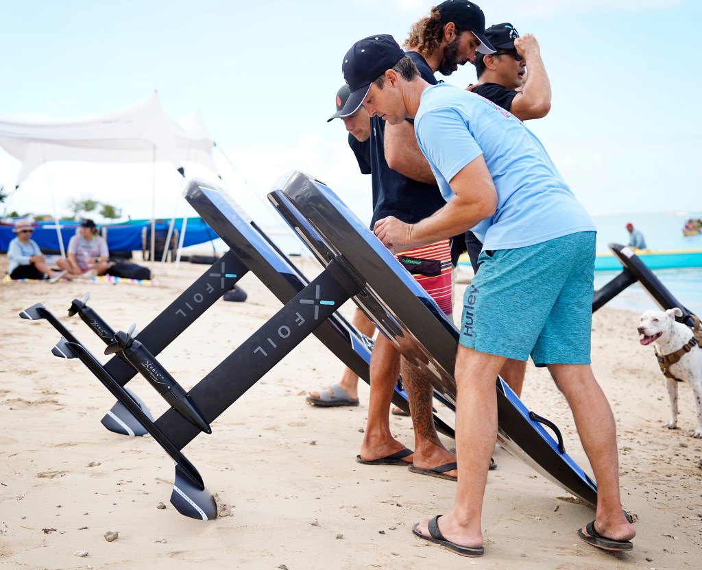 Reggie Clark secures the hatch for an XFoil battery during the Hawaii Efoil Extravaganza 2025 Saturday, Aug. 9, 2025, at Ke‘ehi Lagoon in Honolulu. The first of its kind in Hawaiʻi, the day consisted of trying out e-foils and racing on a closed-circuit track for prizes. (Kevin Fujii/Civil Beat/2025)