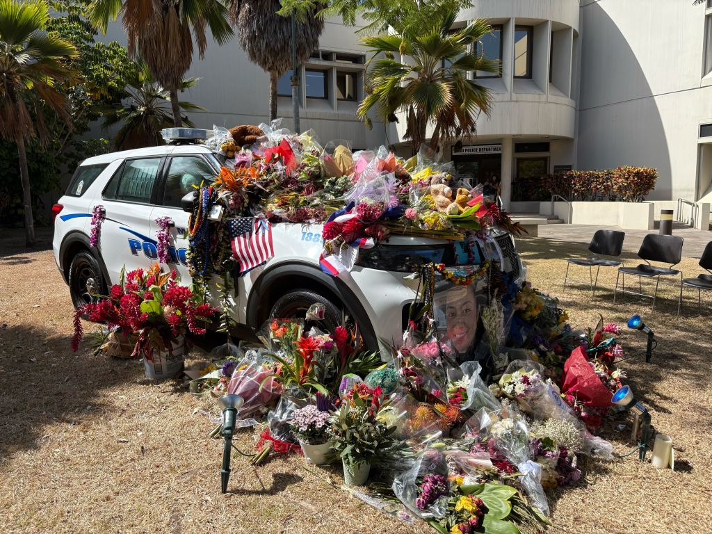 Flowers are piled high outside the police station on Aug. 21, 2025, in honor of slain Maui police officer Suzanne O. (Erin Nolan/Civil Beat/2025)