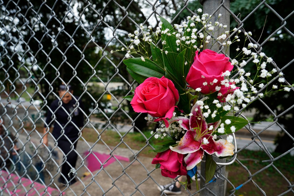 Kapulani Shoaf ascends the stairs from “The Bunker” Thursday, Nov. 20, 2025, where her sibling Kuualoha Shoaf was found dead in Honolulu. Kuualoha also went by Lillie and was a known meth user. Shoaf placed the flowers on the fence. (Kevin Fujii/Civil Beat/2025)