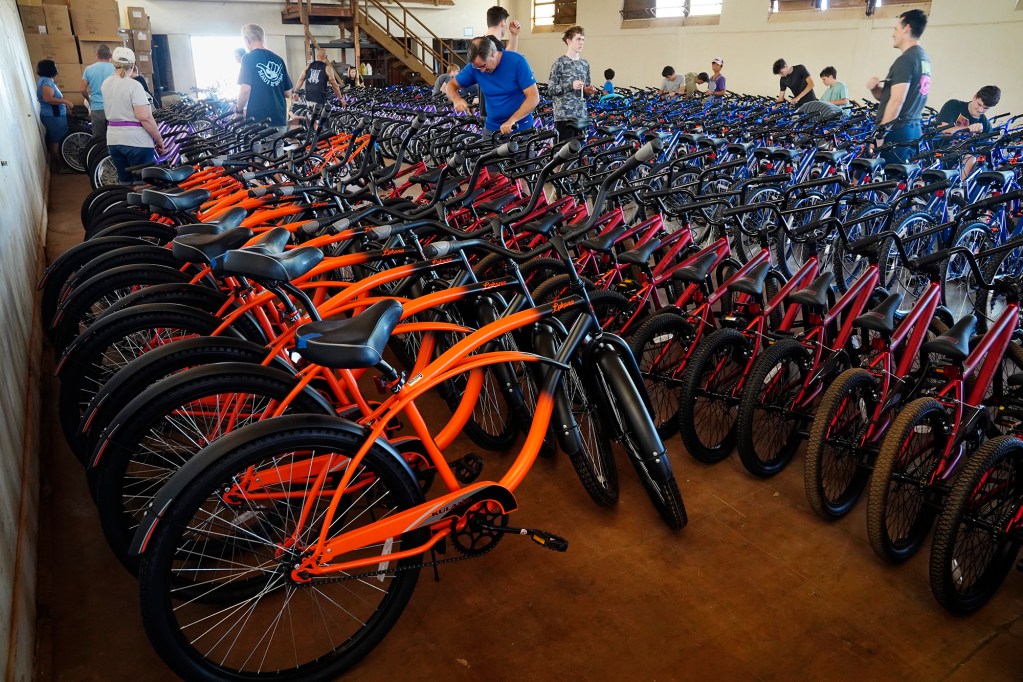 Volunteers work during one of four Jim Falk’s annual Christmas Kids Bike Build days takes place Saturday, Dec. 6, 2025, in Puʻunēnē. Approximately 450 new bicycles are built and will distributed to keiki in Maui County. (Kevin Fujii/Civil Beat/2025)