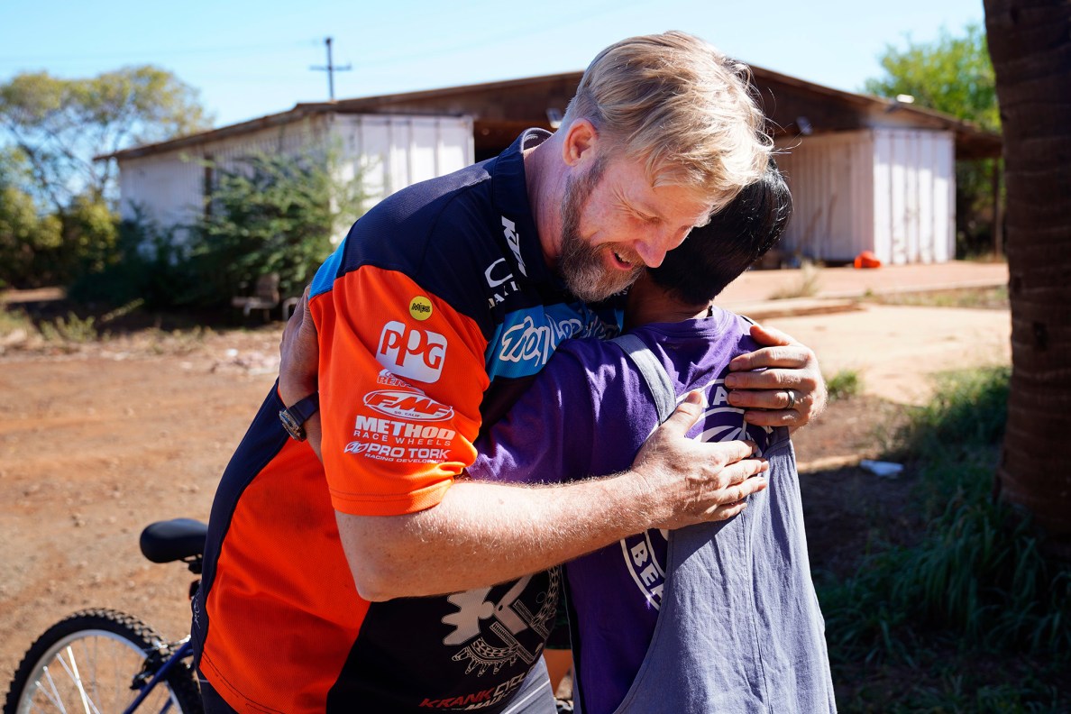 Krank Cycles Maui owner Aaron ”Moose" Reichert gets a hug from Mayumi Oshima during one of Jim Falk’s annual Christmas Kids Bike Build days Saturday, Dec. 6, 2025, in Puʻunēnē. Oshima and her family received new bikes and helmets for their volunteerism with the bike build and their church. (Kevin Fujii/Civil Beat/2025)