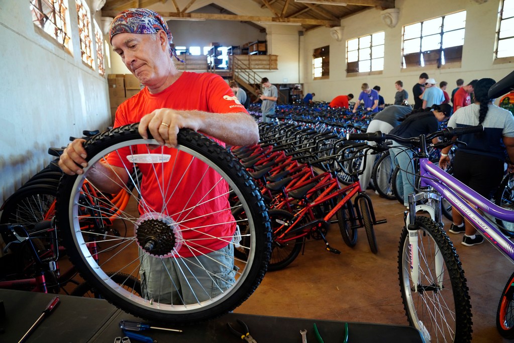 Volunteer Jerry Rice of Wailuku replaces an inner tube during one of four Jim Falk’s annual Christmas Kids Bike Build days Saturday, Dec. 6, 2025, in Puʻunēnē. This is Rice’s fourth year volunteering. “It’s surprising how many new bikes have flat tires,” Rice said. (Kevin Fujii/Civil Beat/2025)