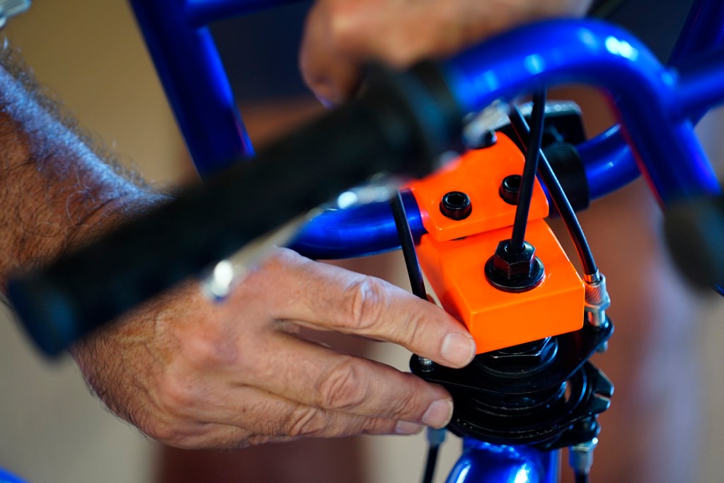 Mike McKenna of Māʻalaea tightens brake cables during one of Jim Falk’s annual Christmas Kids Bike Build days Saturday, Dec. 6, 2025, in Puʻunēnē. (Kevin Fujii/Civil Beat/2025)