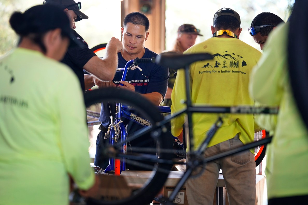 Maui Emergency Management Agency’s Justin Neuhart builds a bicycle during Jim Falk’s annual Christmas Kids Bike Build Wednesday, Dec. 10, 2025, in Kaunakakai, Molokaʻi. Approximately 450 new bicycles are built and will distributed to keiki in Maui County. (Kevin Fujii/Civil Beat/2025)