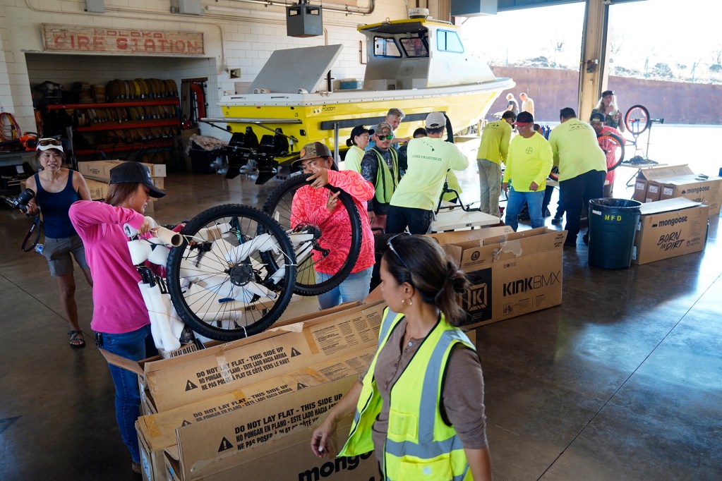 Bayer employees build bikes at the Kaunakakai Fire Station for Jim Falk’s annual Christmas Kids Bike Build Wednesday, Dec. 10, 2025, on Molokaʻi. Approximately 450 new bicycles are built and will distributed to keiki in Maui County. (Kevin Fujii/Civil Beat/2025)