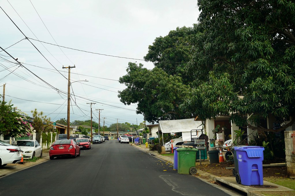 Residents of an ʻEwa Beach neighborhood park their vehicles, recycling and compost bins where sidewalks are usually placed Monday, Dec. 15, 2025. This is Imelda Street. (Kevin Fujii/Civil Beat/2025)