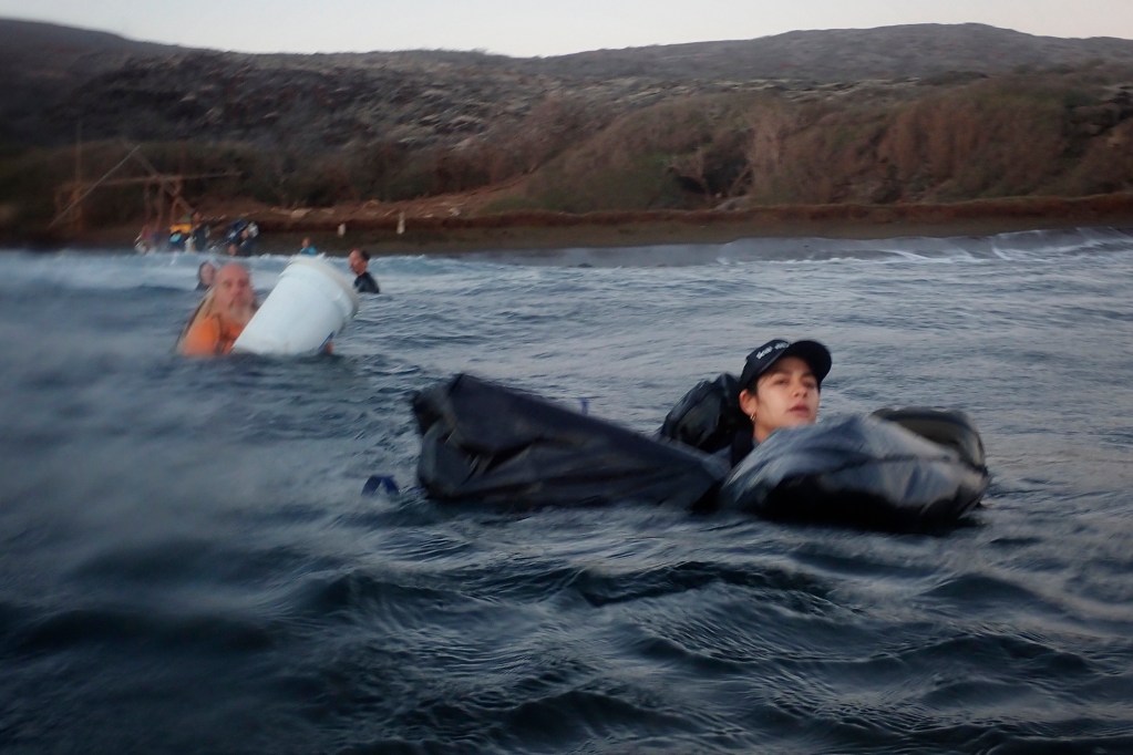 Protect Kahoʻolawe ʻOhana (PKO) Kaulu Lu‘uwai swims ukana (luggage, bags) toward the zodiac Wednesday, Jan. 7, 2026, in Hakioawa. Without a dock or pier, getting to Hakioawa requires getting wet. (Kevin Fujii/Civil Beat/2026)