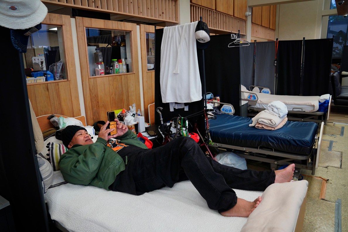 Tony Capati watches a video at the ʻAʻala Respite Center Monday, Jan. 26, 2026, in Honolulu. (Kevin Fujii/Civil Beat/2026)